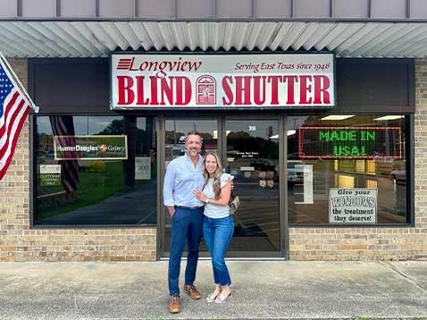 Owners posing for a photo outside the storefront 