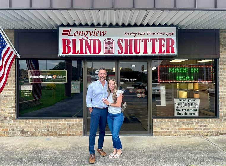 Owners posing for a photo outside the storefront 